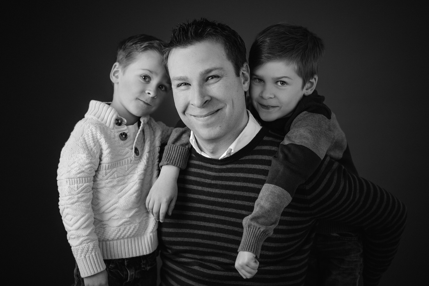Dad and his two sons pose for a family portrait photographed in Calgary's best photography studio