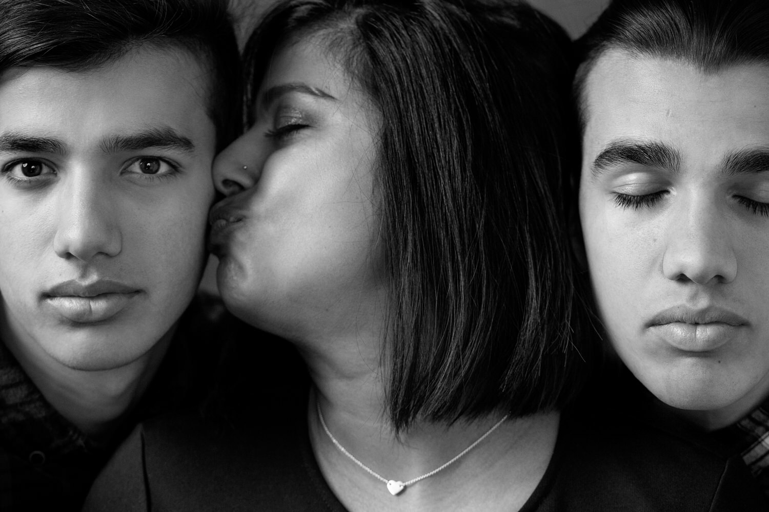 mom and her two boys get close during their studio photography session