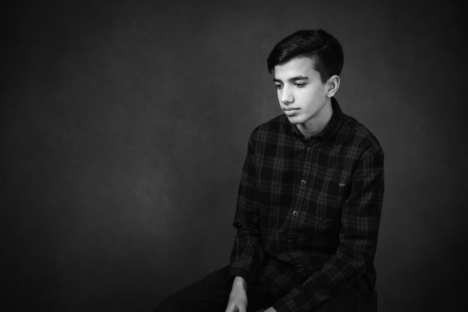A young man thinking during a studio photography shoot in Calgary