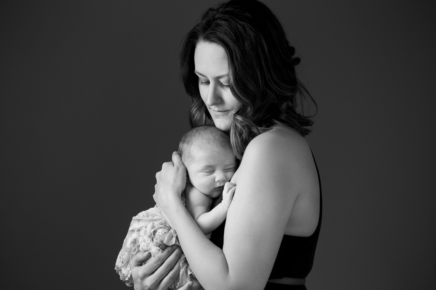 A new parent mom holding her newborn baby during a portrait studio shoto