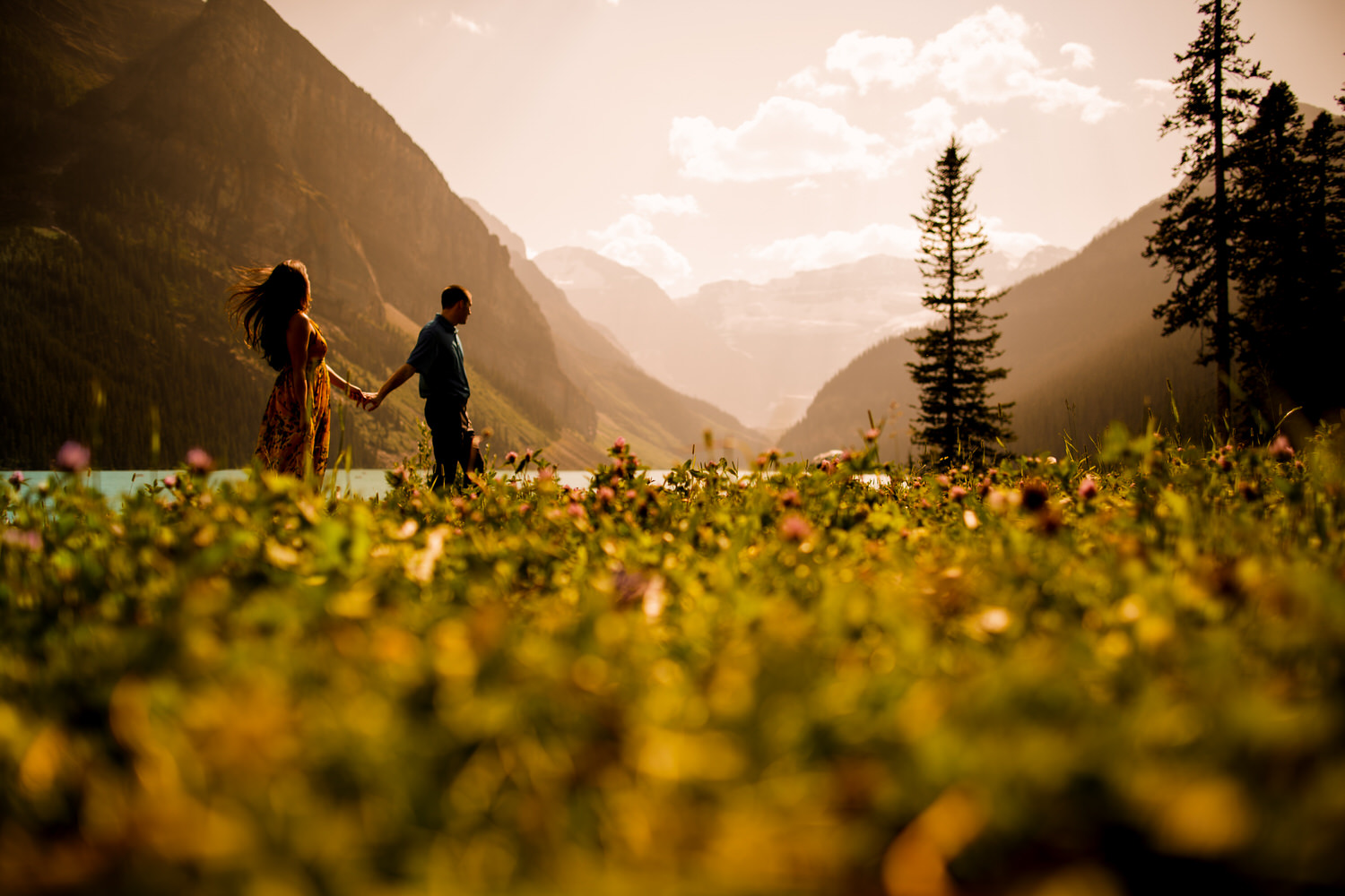 A couple holding hands during their engagement shoot in Lake Louise