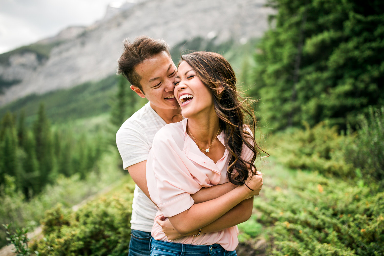 A couple during their engagement shoot in Banff National Park laughing with each other