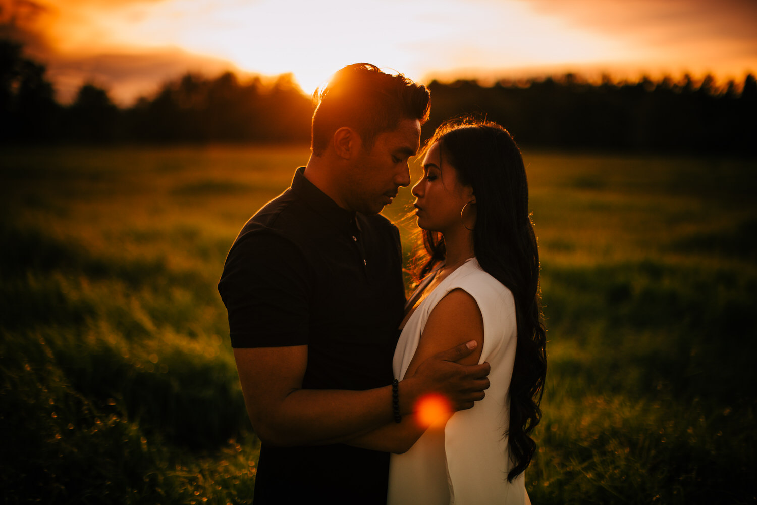 A sunset engagement shoot with a couple looking at each other located in Calgary's Fish Creek Park