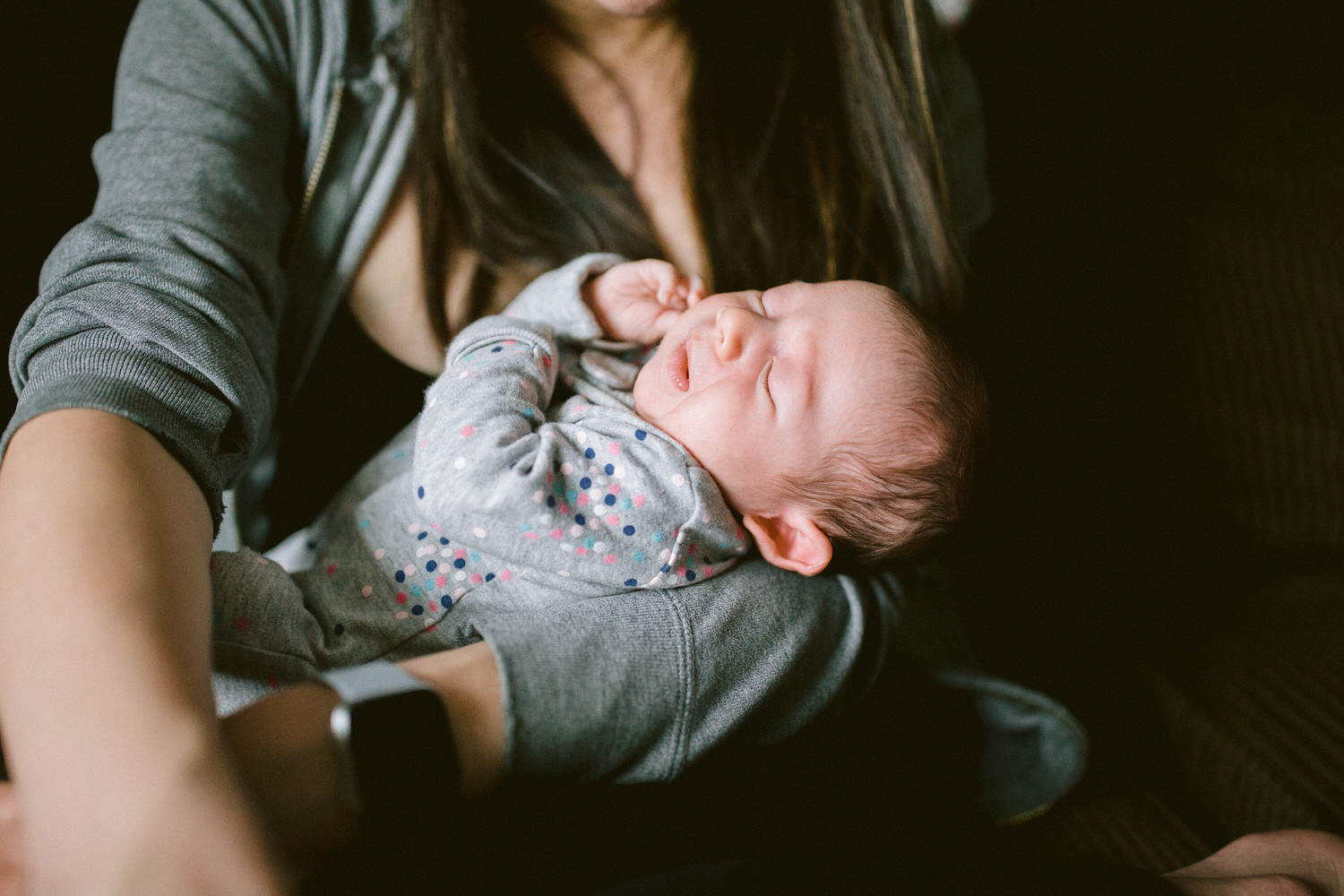 A newborn baby being held during a newborn family photography shoot in Calgary