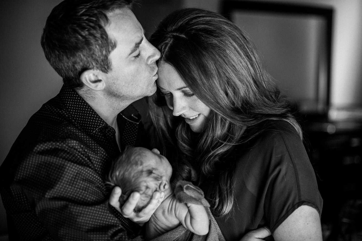 New parents holding their newborn son during a photography session in Calgary